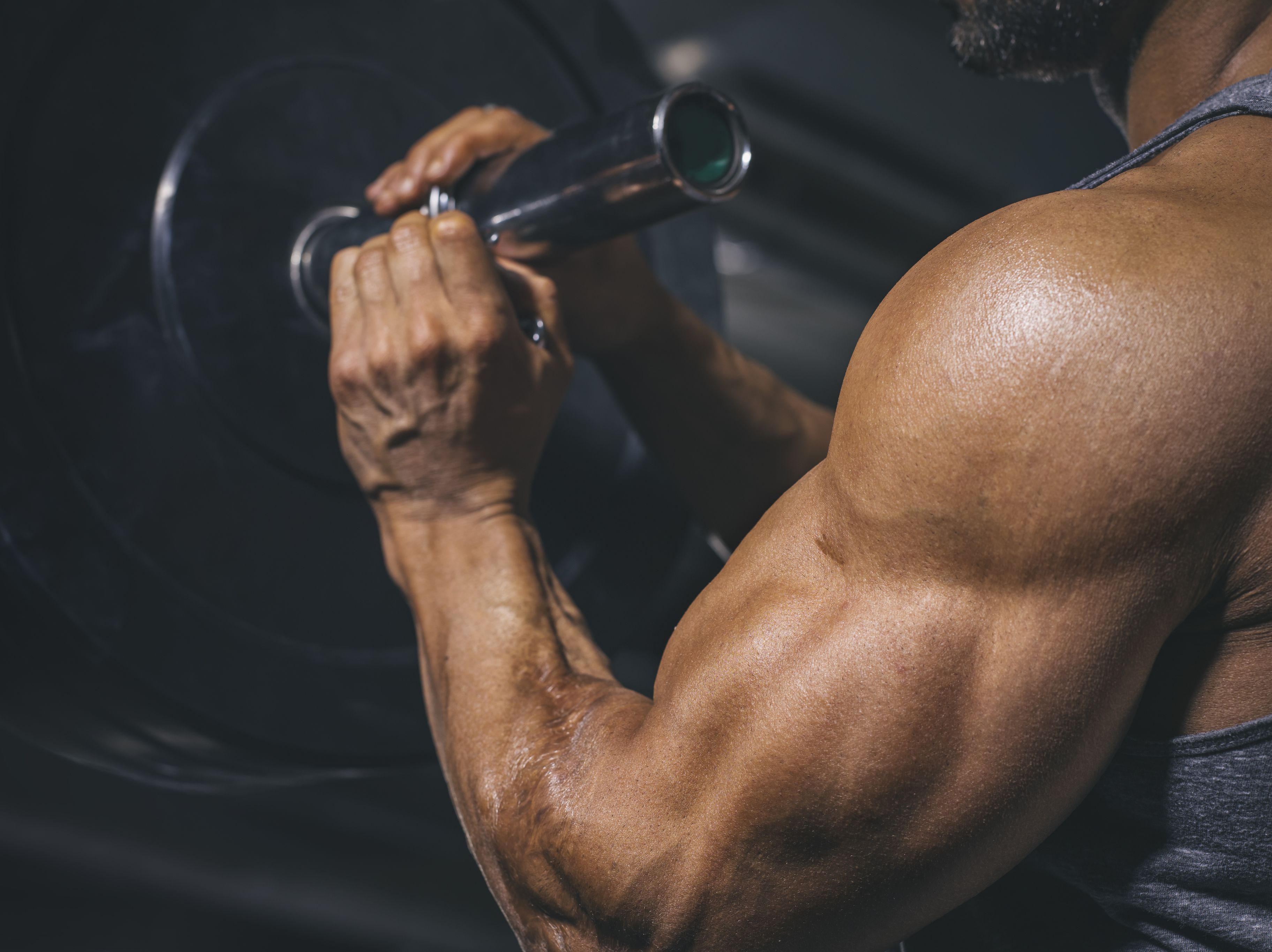 Bodybuilder preparing a barbell on a power rack in gym