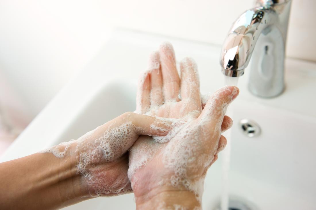 Person washing hands with soapy running water