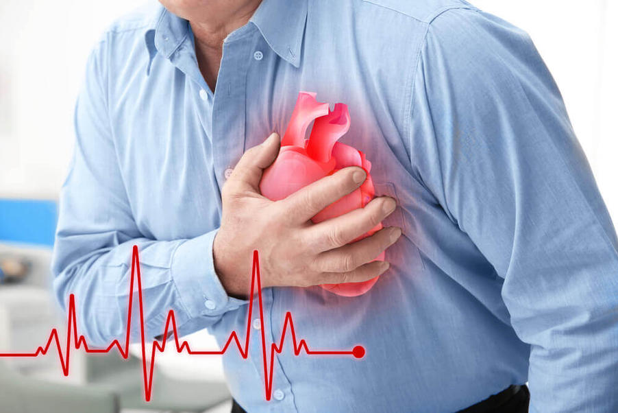 man clutches chest having a heart attack