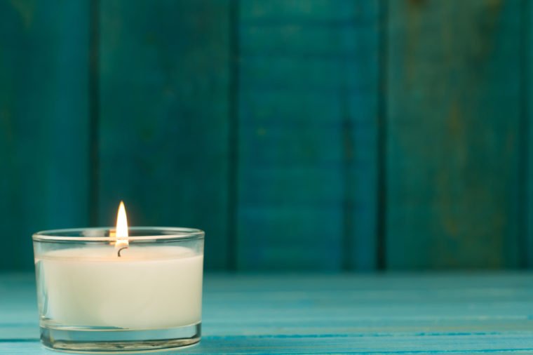 light burning brightly candles on old wooden background. Spa, meditation, ritual, flavored. turquoise color