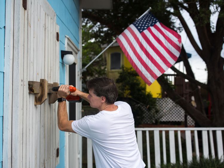 A man helps board up Aussie Island surf shop on September 11, 2018 in Wrightsville, North Carolina in anticipation of Hurricane Florence&#39;s high storm surge