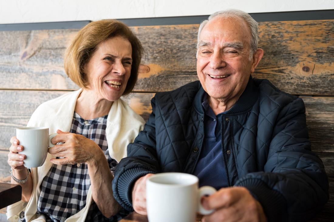 Older adults laughing with coffee