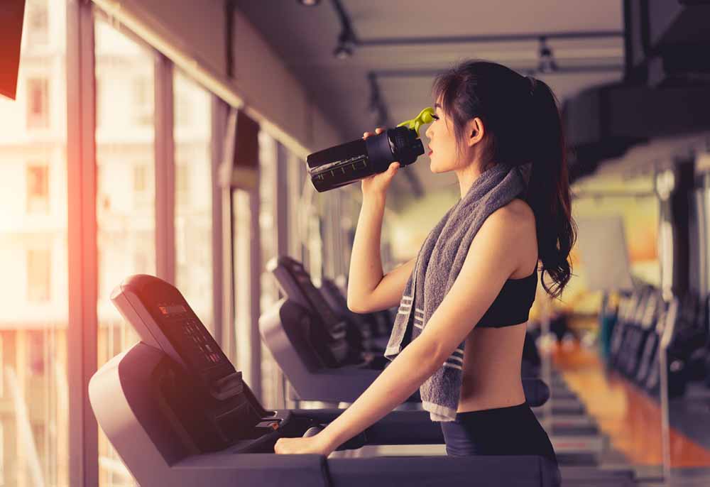 Low-calorie-weight-loss-shakes-woman-drinking-shake-on-treadmill