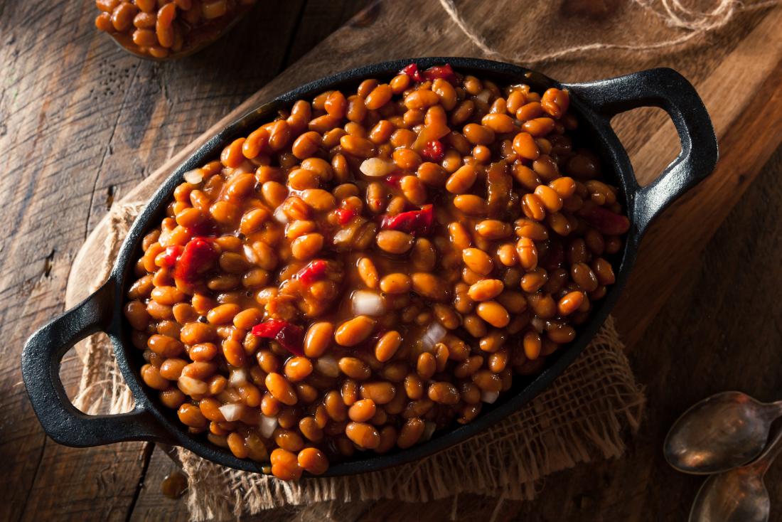 Cooked baked beans in dish on wooden table