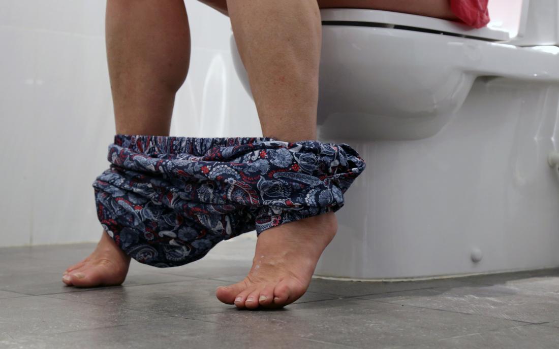 a woman sat on the toilet because she has proctitis