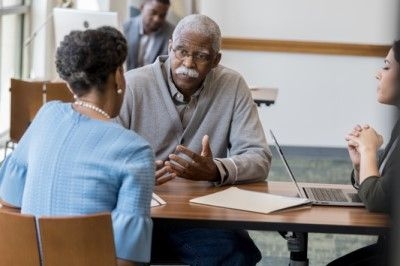 man with dementia talking with his daughter and an advisor