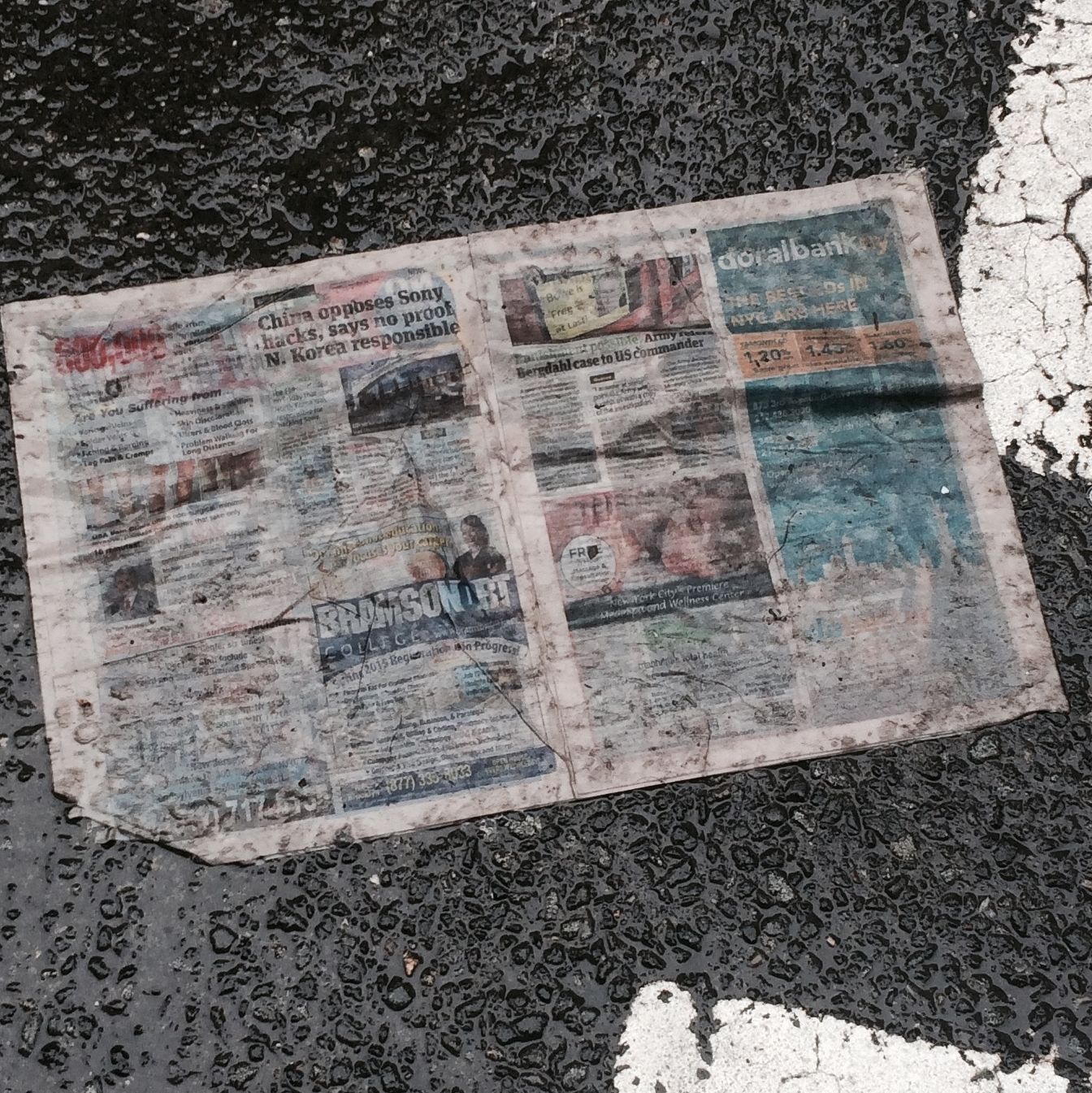 High Angle View Of Newspaper On Wet Street