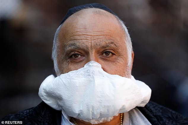 A man is seen using a nappy as a makeshift face mask in Brooklyn, New York City