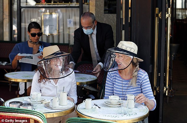 Coffee and screen: Cafe customers in Paris’s Latin Quarter. The Prime Minister is also under mounting pressure to halve the two-metre social distancing rule, which industry chiefs say is unworkable