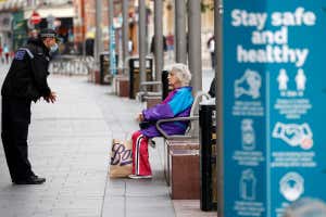 A police officer talks to a woman as he patrols along a street, following a local lockdown in Leicester