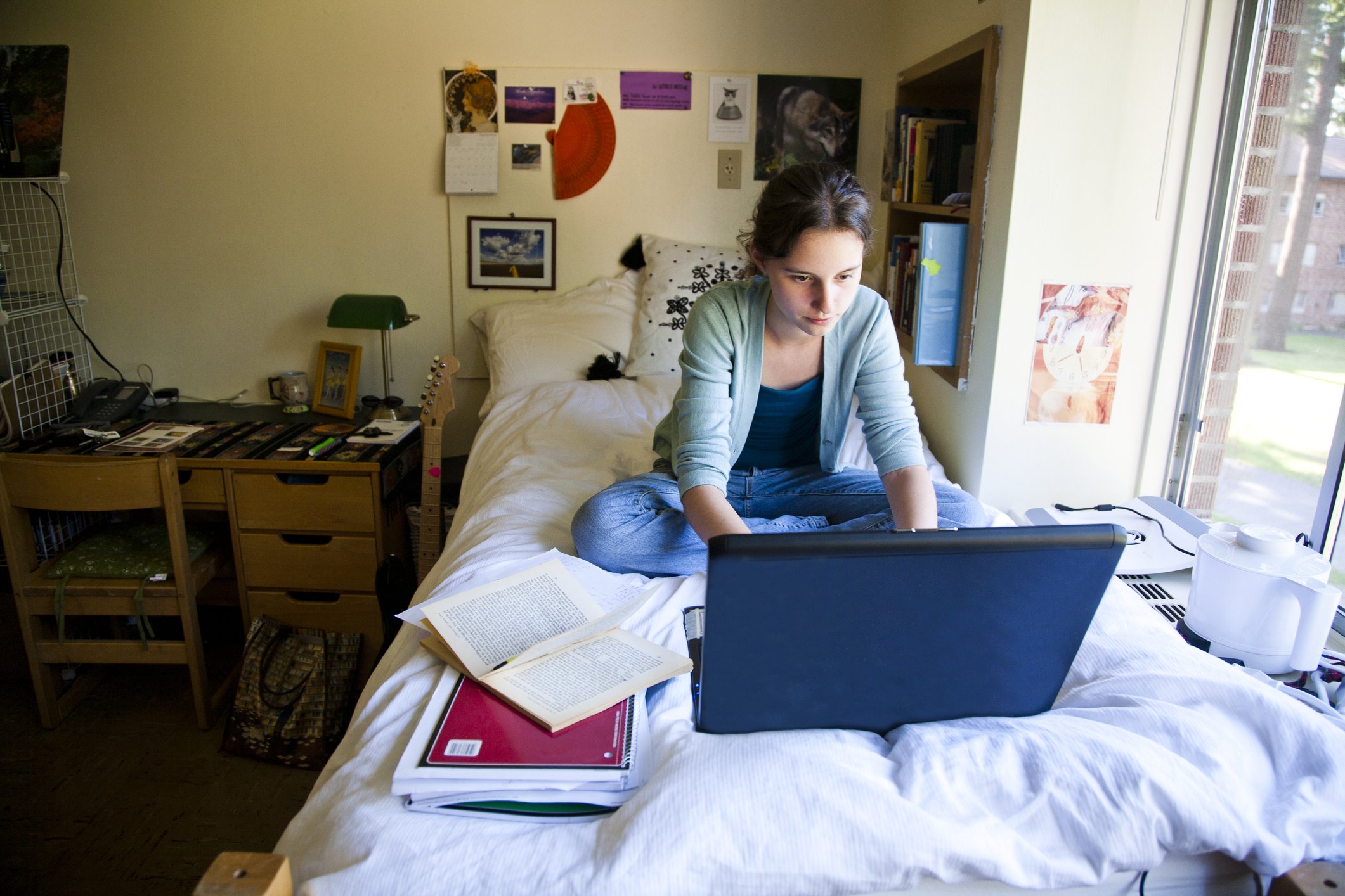 Female college student in her dorm room working on computer