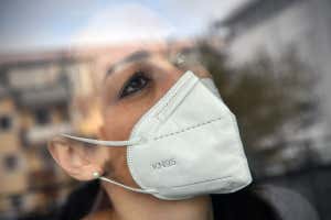 woman wearing face mask behind a window